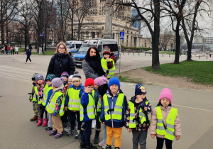 Nauczycielki wraz z dziećmi pozują do zdjęcia pod Pałacem Kultury i Nauki.