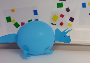 Dinozaur zrobiony z niebieskiego balona i papieru.
