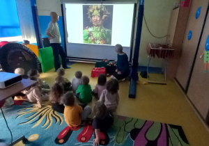 Warsztaty malarskie Fundacji Szkatułka. Dzieci oglądają portret na dużym ekranie.
