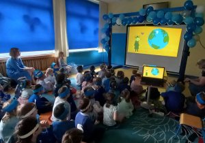 Urodziny Kropelki. Dzieci oglądają film o oszczędzaniu wody na dużym ekranie.