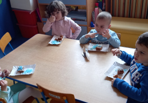 Urodziny Kropelki. Dzieci siedzą przy stolikach i jedzą niebieską galaretkę.