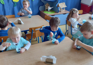 Urodziny Kropelki. Dzieci siedzą przy stolikach i jedzą niebieską galaretkę.