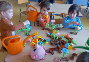 Dzieci bawią się układanką przestrzenną - budują kwiatki.