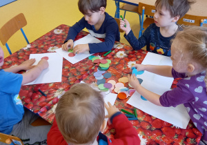Dzieci układają z kółek kształt kwiatka.