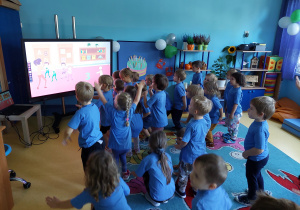 Dzień przedszkolaka- dzieci ćwiczą przy tablicy interaktywnej.