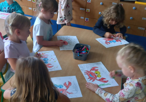 Dzieci kolorują sylwetkę raczka.