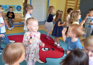 Dzieci tańczą i grają na instrumentach.