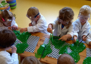 Dzieci rozciągają zielonego slima.