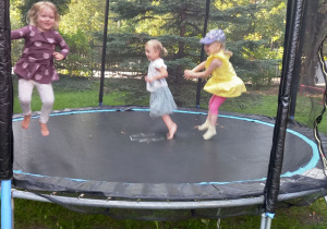 Dziewczynki skaczą na trampolinie na placu zabaw.