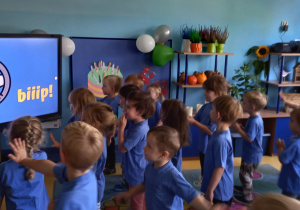 Dzień przedszkolaka. Dzieci ruszają się według instrukcji wyświetlanej na tablicy multimedialnej.