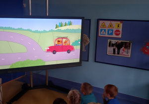 Dzieci oglądają film edukacyjny o ruchu drogowym.