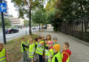 Dzieci obserwują znaki i ruch drogowy na spacerze w okolicach przedszkola.