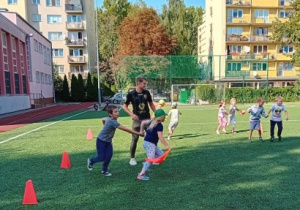 Dzieci biegają podczas treningu piłkarskiego.