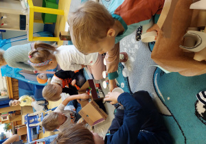 Dzieci bawią się materiałami do recyclingu.