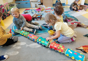 Dzieci bawią się pociągiem z wytłaczanek po jajkach.