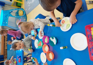 Dzieci projektują własną sałatkę na talerzyku.