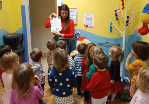 Dzieci z nauczycielem czytają list od Świętego Mikołaja.