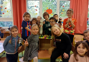 Dzieci pokazują zabawkowy telewizor wykonany z kartonu i plastiku.