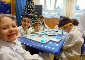 Dzieci obserwują reakcje chemiczne podczas wykonywania eksperymentu z ciekłym kryształem.