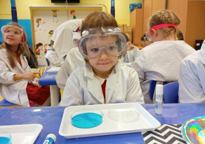 Dzieci obserwują reakcje chemiczne podczas wykonywania eksperymentu z ciekłym kryształem.
