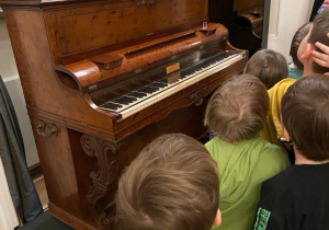 Wycieczka do muzeum Chopina. Dzieci stoją obok pianina.
