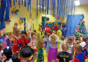 Dzieci tańczą na balu karnawałowym.