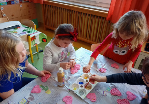 Dzieci malują serduszka z masy solnej.