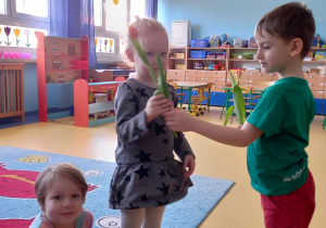 Chłopiec daje dziewczynce różowego tulipana.