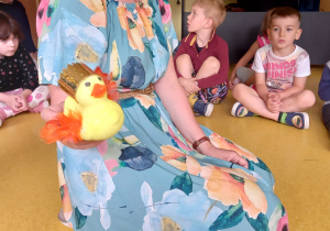 Aktorka pokazuje dzieciom figurkę złotej kaczki.