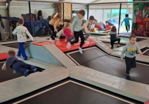 Wycieczka. Dzieci skaczą na trampolinach.