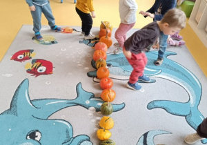 Dzieci skaczą przez dynie.