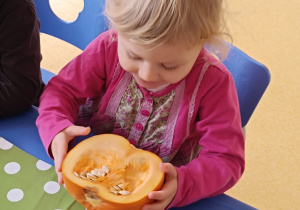 Dziewczynka ogląda środek dyni.