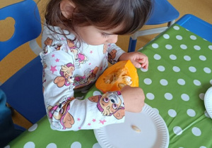 Dziewczynka wyjmuje pestki z dyni.
