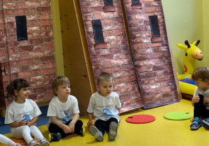 Dzieci siedzą na krążkach.