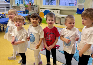 Dzieci stoją i uśmiechają się do zdjęcia.