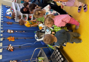 Dzieci stoją przed robotem kuchennym i robią babeczki.