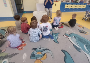 Dzieci patrzą na pluszowe słońce pokazywane przez nauczycielkę.