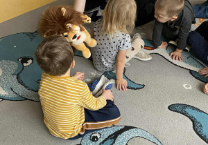 Dzieci witają się z maskotką lwa.