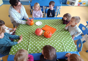 Dzieci siedzą na krzesłach przy stole.