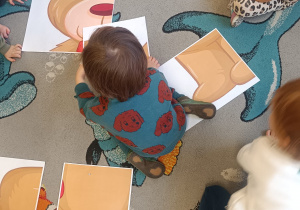 Chłopiec układa duże puzzle.