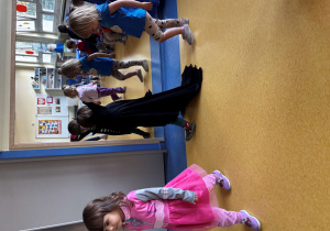 Dzieci idą w kole w swoich przebraniach.