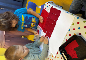 Dzieci wyklejają mapę Polski.