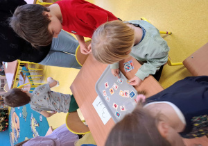 Zajęcia edukacyjne, dzieci bawią się w pocztę i kupują znaczki.