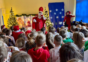 Dzieci tańczą i wygłupiają się z Mikołajem.