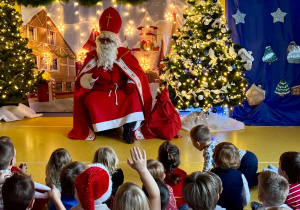 Dzieci słuchają opowieści Świętego Mikołaja.