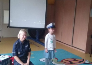 Dziewczynka przymierza czapkę policjantki.