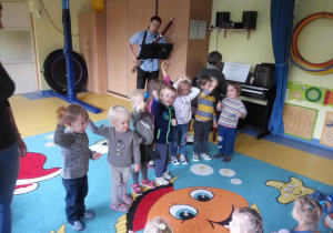 Dzieci tańczą przy dźwiękach instrumentu.