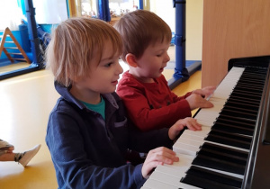 Dzieci tworzą muzykę na pianinie