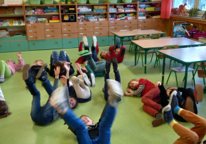 Dzieci ćwiczą pojedynczo na podłodze.